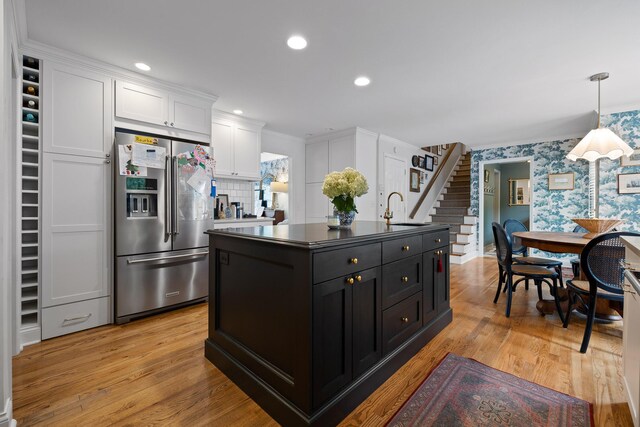 9420 Mountain Shadows Dr, Chattanooga, TN 37421 - kitchen featuring high quality fridge, white cabinets, wallpapered walls, a kitchen island with sink, and pendant lighting
