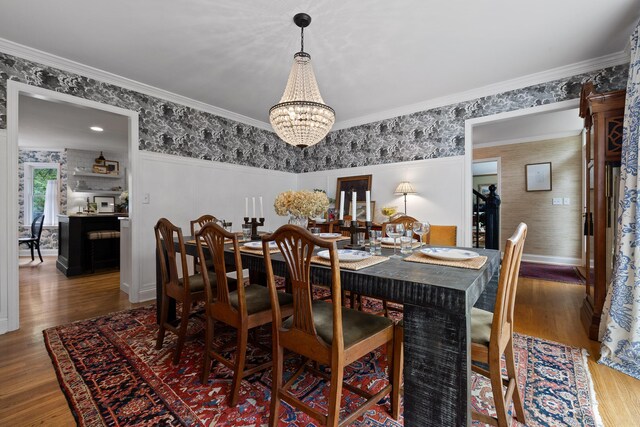 9420 Mountain Shadows Dr, Chattanooga, TN 37421 - dining space with wallpapered walls, a chandelier, wood finished floors, and ornamental molding