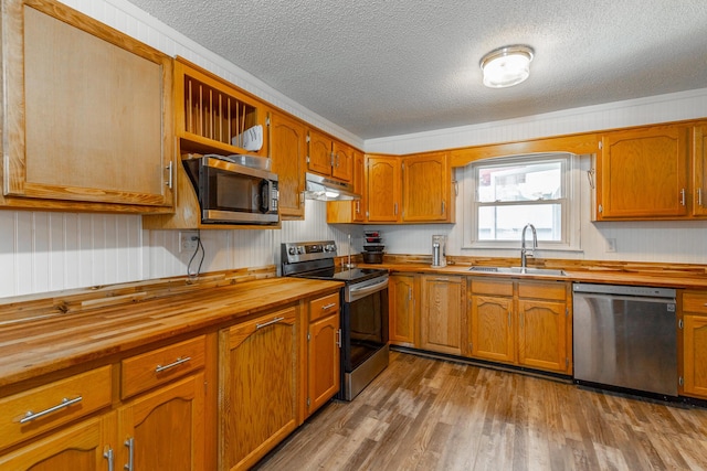 1602 Prater Rd, Chattanooga, TN 37412 - kitchen with stainless steel appliances, wood counters, a textured ceiling, wood finished floors, and under cabinet range hood
