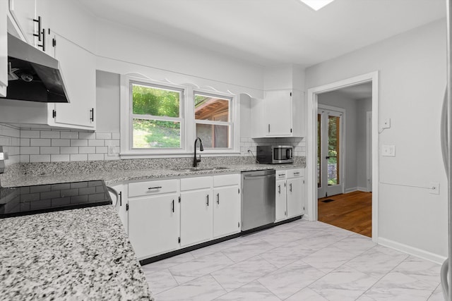 3671 Thrushwood Dr, Chattanooga, TN 37415 - kitchen featuring appliances with stainless steel finishes, ventilation hood, white cabinetry, backsplash, and light marble finish floors