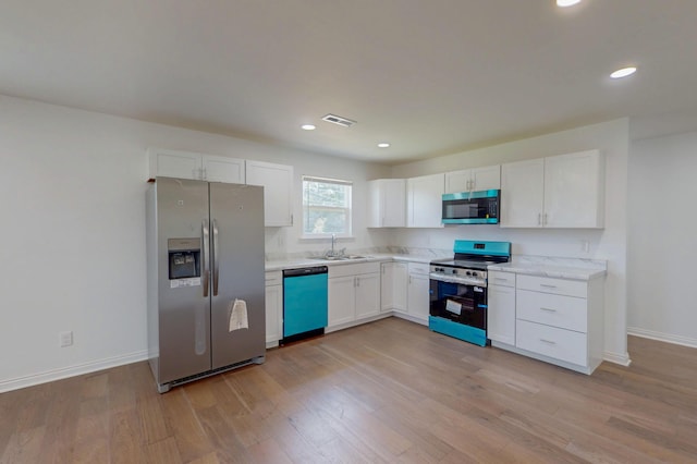 1150 Lang St NE, Cleveland, TN 37311 - kitchen featuring appliances with stainless steel finishes, white cabinetry, light wood finished floors, light countertops, and recessed lighting