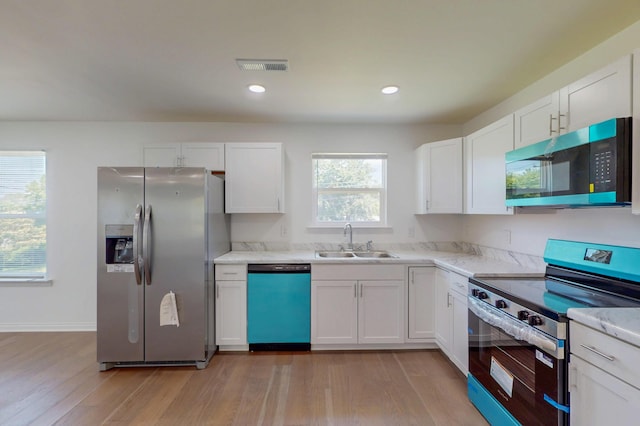 1150 Lang St NE, Cleveland, TN 37311 - kitchen with appliances with stainless steel finishes, white cabinets, light wood finished floors, light stone countertops, and recessed lighting