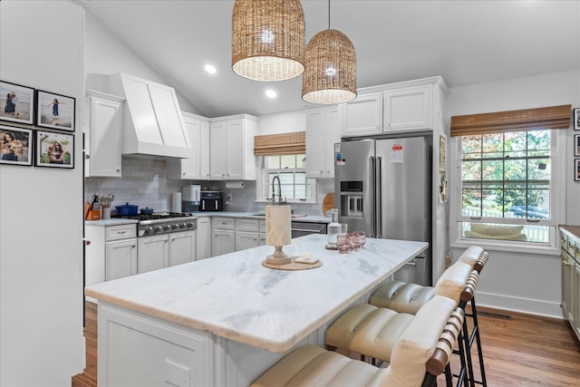110 Linden St, Lookout Mountain, TN 37350 - kitchen with a breakfast bar area, appliances with stainless steel finishes, tasteful backsplash, white cabinets, and vaulted ceiling