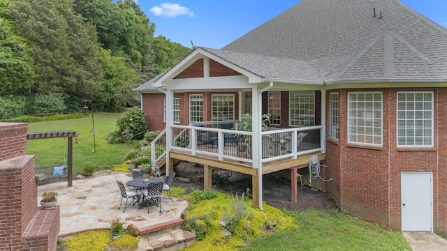 4101 Finch Ln, Chattanooga, TN 37419 - back of property featuring brick siding, a lawn, roof with shingles, a patio, and a deck