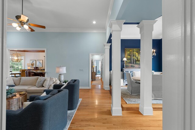 4101 Finch Ln, Chattanooga, TN 37419 - living room featuring a ceiling fan, ornamental molding, decorative columns, light wood finished floors, and a chandelier