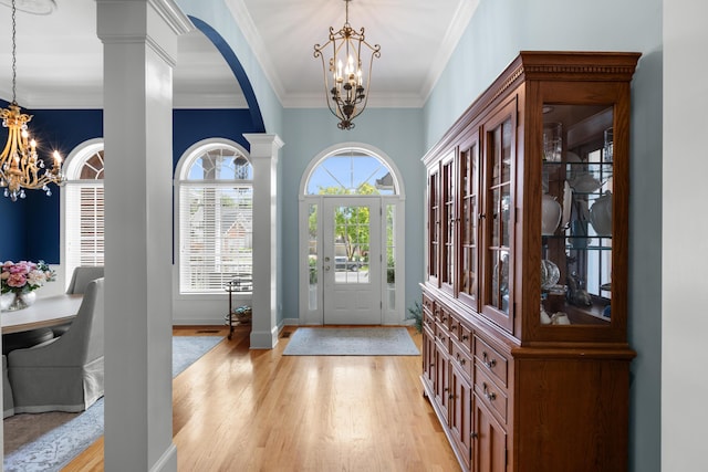 4101 Finch Ln, Chattanooga, TN 37419 - foyer entrance featuring a chandelier, light wood finished floors, arched walkways, crown molding, and decorative columns
