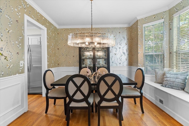 1003 Woodfern Trl, Hixson, TN 37343 - dining space with a chandelier, ornamental molding, wallpapered walls, wainscoting, and wood finished floors