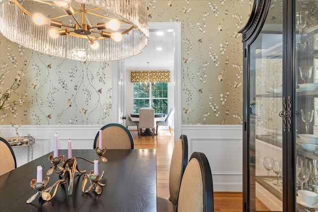 1003 Woodfern Trl, Hixson, TN 37343 - dining area with wallpapered walls, a wainscoted wall, wood finished floors, a chandelier, and a decorative wall