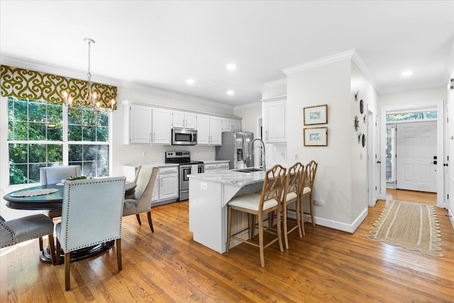1003 Woodfern Trl, Hixson, TN 37343 - kitchen featuring stainless steel appliances, a kitchen bar, wood finished floors, a chandelier, and recessed lighting