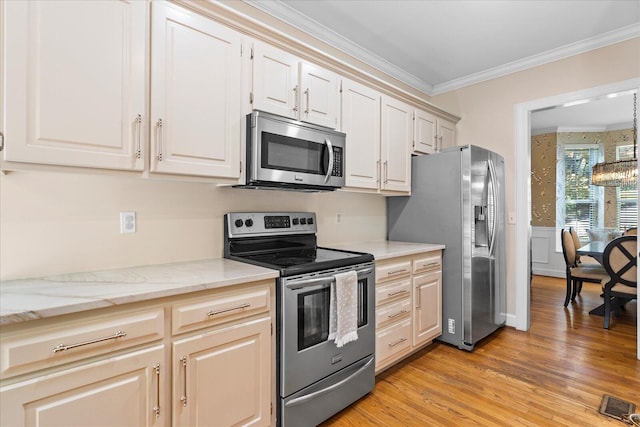 1003 Woodfern Trl, Hixson, TN 37343 - kitchen featuring appliances with stainless steel finishes, ornamental molding, light wood-style flooring, light stone countertops, and a wainscoted wall