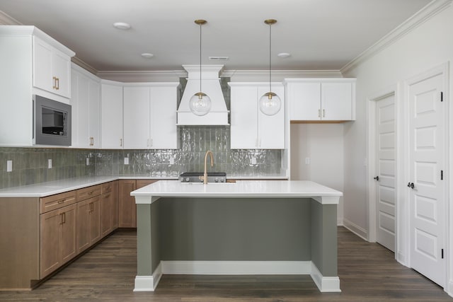 7853 Lemonade St, Chattanooga, TN 37421 - kitchen featuring stainless steel microwave, custom exhaust hood, a kitchen island with sink, dark wood-style floors, and crown molding
