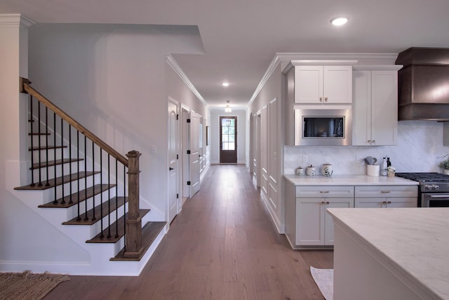 7829 Lemonade St, Chattanooga, TN 37421 - kitchen with custom exhaust hood, appliances with stainless steel finishes, crown molding, tasteful backsplash, and wood finished floors
