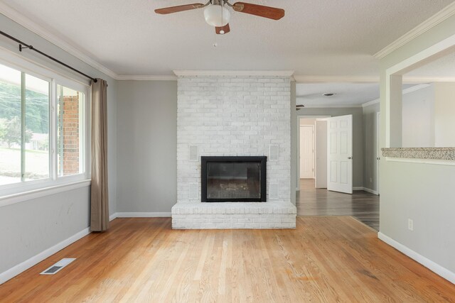 5229 Loblolly Ln, Ooltewah, TN 37363 - unfurnished living room with a fireplace, ornamental molding, a ceiling fan, plenty of natural light, and wood finished floors