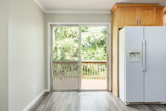 5229 Loblolly Ln, Ooltewah, TN 37363 - kitchen with white fridge with ice dispenser, light wood-type flooring, and ornamental molding
