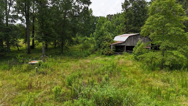 393 Sim Goodwin Rd SW, Mcdonald, TN 37353 - view of yard featuring a barn, a wooded view, and an outbuilding