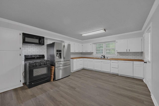 176 Depot St, Soddy Daisy, TN 37379 - kitchen featuring black appliances, butcher block counters, wood finished floors, decorative backsplash, and white cabinetry