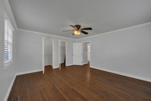 176 Depot St, Soddy Daisy, TN 37379 - unfurnished bedroom featuring dark wood-type flooring, ornamental molding, a textured ceiling, a ceiling fan, and a walk in closet