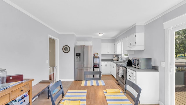 4111 Lost Oaks Dr, Ooltewah, TN 37363 - kitchen featuring appliances with stainless steel finishes, under cabinet range hood, white cabinetry, crown molding, and dark countertops