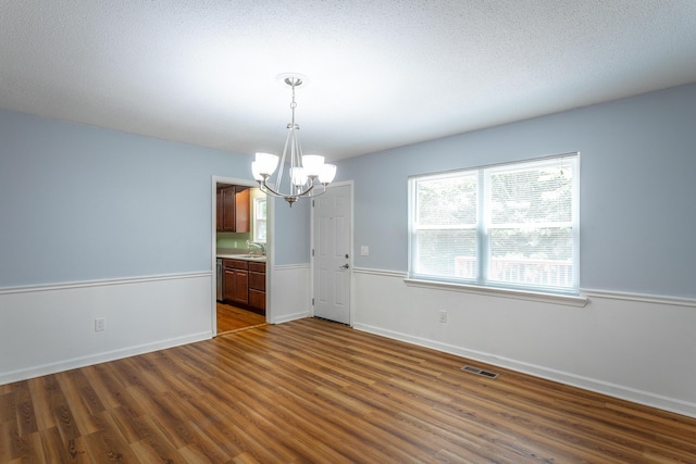 8217 Rolling Stone Ln, Ooltewah, TN 37363 - spare room featuring a chandelier, dark wood-style floors, and a textured ceiling