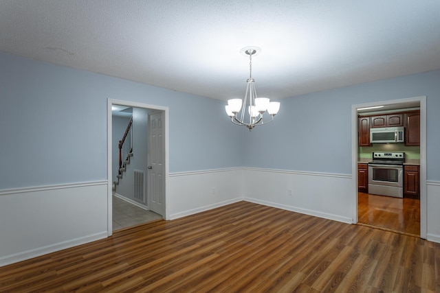 8217 Rolling Stone Ln, Ooltewah, TN 37363 - unfurnished room featuring dark wood-type flooring, a chandelier, and stairs