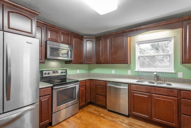 8217 Rolling Stone Ln, Ooltewah, TN 37363 - kitchen featuring stainless steel appliances, light wood-type flooring, light countertops, and a textured ceiling