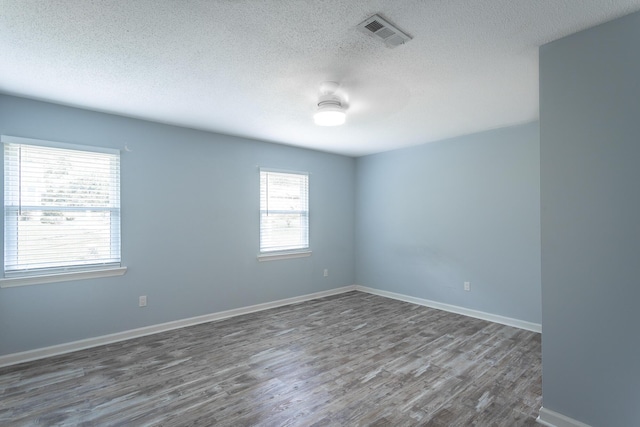 8217 Rolling Stone Ln, Ooltewah, TN 37363 - unfurnished room with a textured ceiling, dark wood finished floors, and healthy amount of natural light