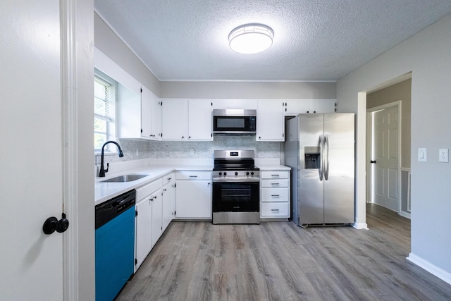 1340 Michael Ln, Hixson, TN 37343 - kitchen featuring stainless steel appliances, a textured ceiling, light wood-style flooring, tasteful backsplash, and white cabinetry
