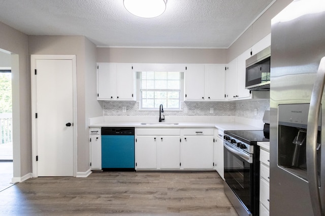 1340 Michael Ln, Hixson, TN 37343 - kitchen with stainless steel appliances, light wood-type flooring, white cabinetry, decorative backsplash, and a textured ceiling