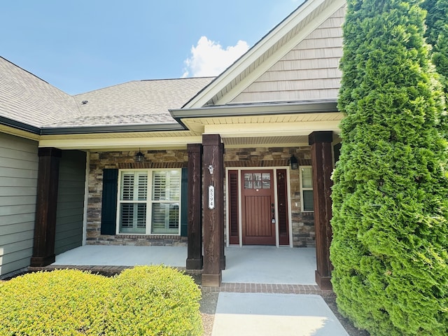 8594 River Birch Loop, Ooltewah, TN 37363 - doorway to property with a porch, stone siding, and a shingled roof