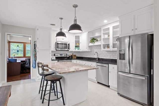 28 Lynn Rd, Signal Mountain, TN 37377 - kitchen with appliances with stainless steel finishes, decorative backsplash, a kitchen island, white cabinetry, and recessed lighting