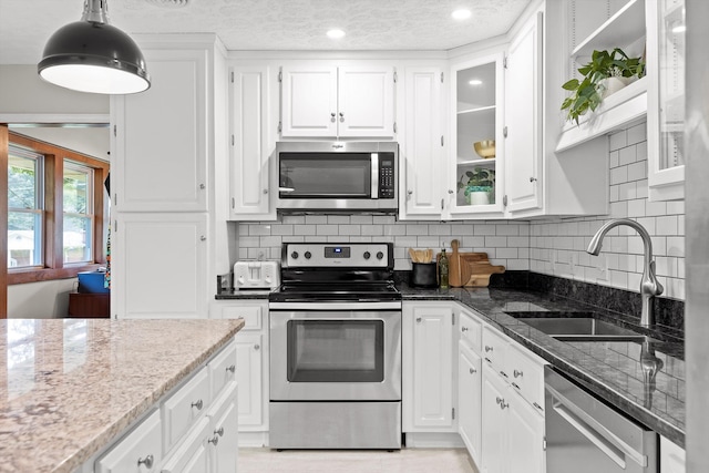 28 Lynn Rd, Signal Mountain, TN 37377 - kitchen with stainless steel appliances, white cabinetry, dark stone counters, backsplash, and recessed lighting