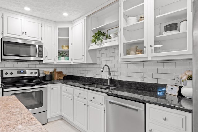 28 Lynn Rd, Signal Mountain, TN 37377 - kitchen featuring appliances with stainless steel finishes, white cabinetry, decorative backsplash, glass insert cabinets, and a textured ceiling