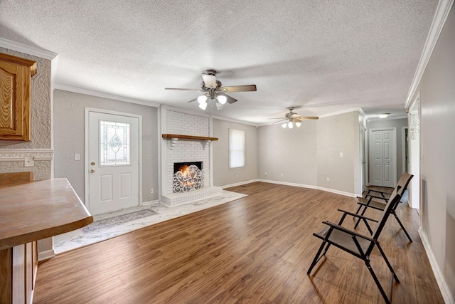 15 Moon Beam Cir, Rock Spring, GA 30739 - unfurnished living room with a fireplace, ornamental molding, wood finished floors, a ceiling fan, and a textured ceiling