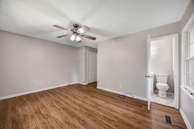 15 Moon Beam Cir, Rock Spring, GA 30739 - unfurnished bedroom featuring wood finished floors, a textured ceiling, connected bathroom, and a ceiling fan