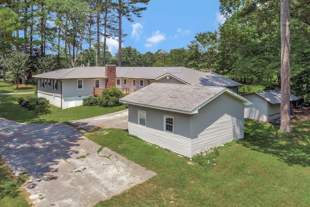 15 Moon Beam Cir, Rock Spring, GA 30739 - view of front of house with a front lawn, a chimney, a storage unit, and driveway