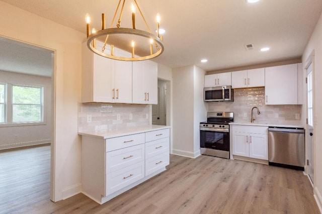 318 Yates Springs Rd, Ringgold, GA 30736 - kitchen with stainless steel appliances, light wood finished floors, white cabinetry, backsplash, and recessed lighting