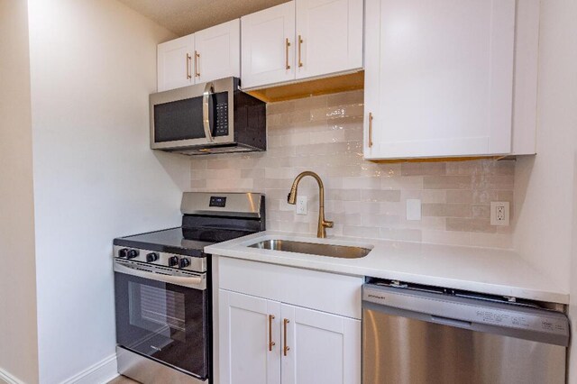 318 Yates Springs Rd, Ringgold, GA 30736 - kitchen featuring stainless steel appliances, white cabinets, light countertops, and decorative backsplash