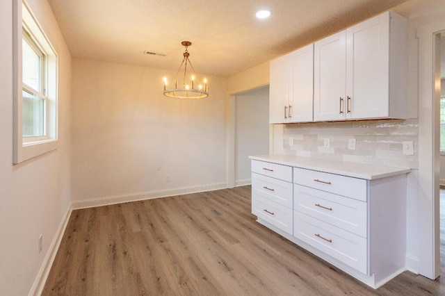 318 Yates Springs Rd, Ringgold, GA 30736 - kitchen featuring light wood finished floors, white cabinets, a chandelier, light countertops, and tasteful backsplash