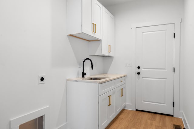 6821 Lakeshore Dr, Chattanooga, TN 37416 - laundry area with light wood-type flooring, electric dryer hookup, and cabinet space