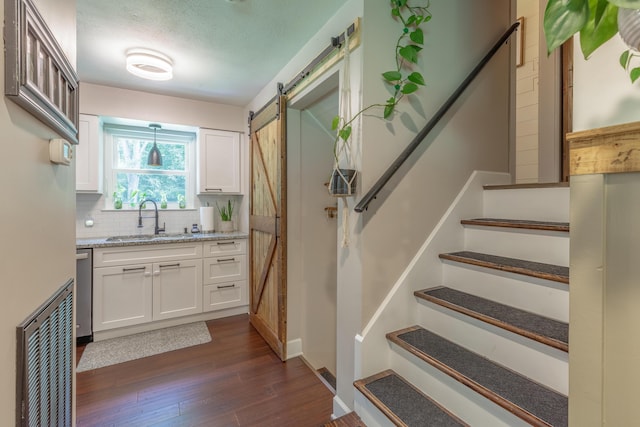 88 Sparrow Ln, Ringgold, GA 30736 - kitchen with a barn door, white cabinetry, decorative backsplash, and dark wood-type flooring