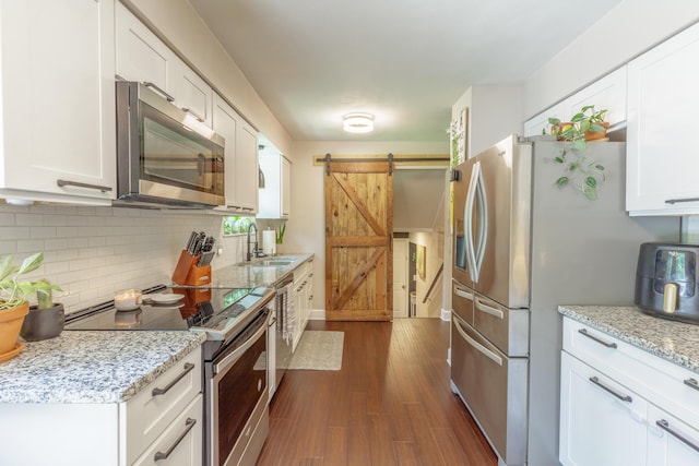 88 Sparrow Ln, Ringgold, GA 30736 - kitchen with stainless steel appliances, a barn door, tasteful backsplash, and white cabinetry