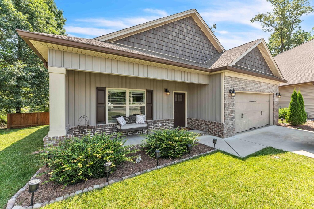 1891 Preservation Dr NE, Cleveland, TN 37323 - view of front of property featuring brick siding, covered porch, an attached garage, and concrete driveway