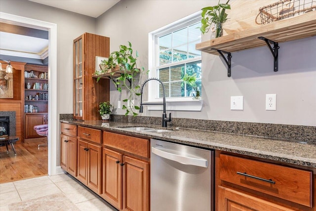 7918 Chianti Way, Chattanooga, TN 37421 - kitchen featuring stainless steel dishwasher, brown cabinets, dark stone countertops, light tile patterned flooring, and a fireplace