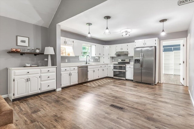 2416 Mourning Dove Ln, Signal Mountain, TN 37377 - kitchen with stainless steel appliances, under cabinet range hood, white cabinetry, dark wood finished floors, and light countertops