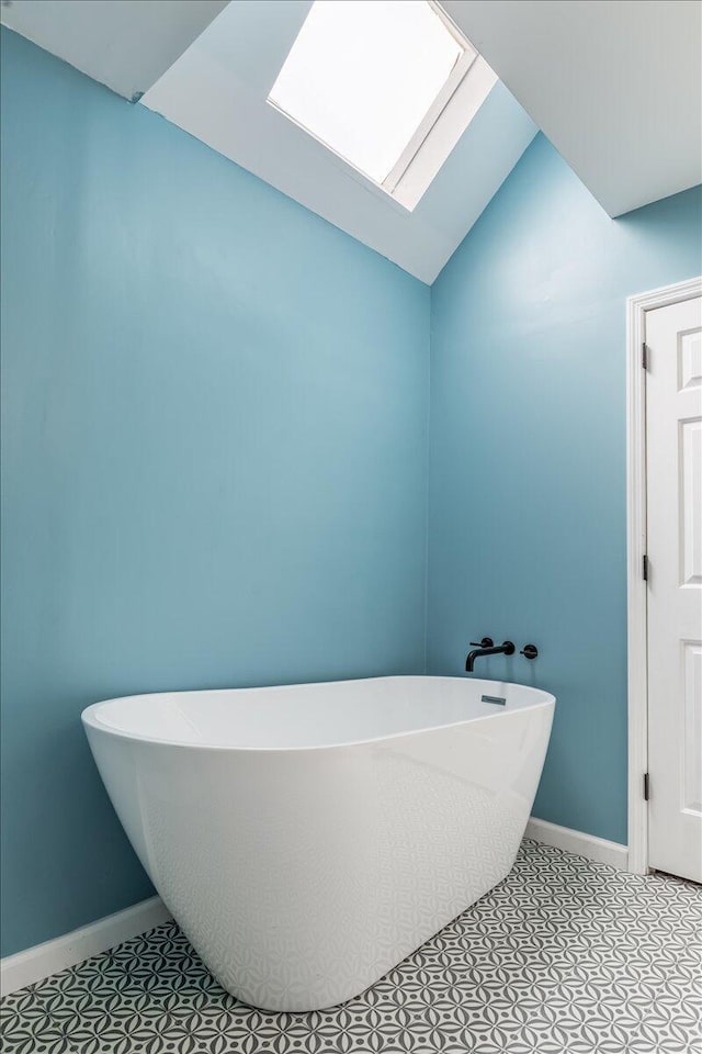 2416 Mourning Dove Ln, Signal Mountain, TN 37377 - full bathroom with a freestanding tub, a skylight, lofted ceiling, and tile patterned floors