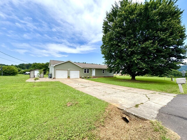1828 Saunders Rd, Ringgold, GA 30736 - ranch-style house with driveway, a garage, a front lawn, and a shed
