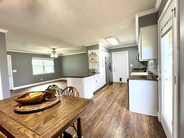 1828 Saunders Rd, Ringgold, GA 30736 - kitchen featuring stainless steel fridge, dark countertops, a textured ceiling, ornamental molding, and dark wood-style floors