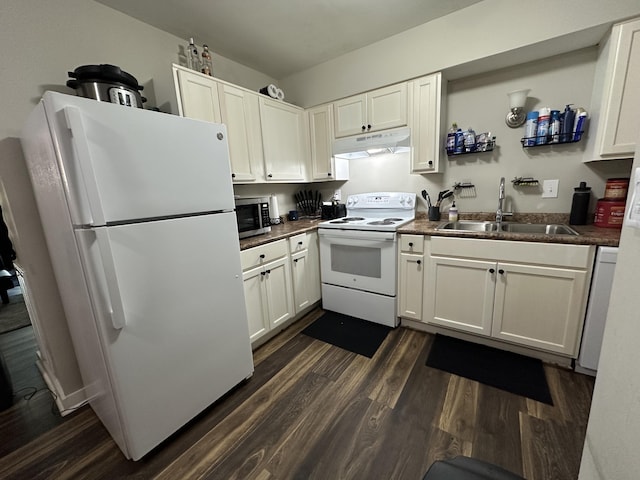 3420 Birchwood Dr, Chattanooga, TN 37406 - kitchen with white appliances, under cabinet range hood, dark countertops, dark wood-style floors, and white cabinets