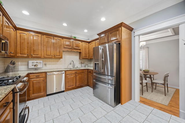 2507 Saint Lucie Ct, Chattanooga, TN 37421 - kitchen with stainless steel appliances, crown molding, backsplash, light stone countertops, and brown cabinets
