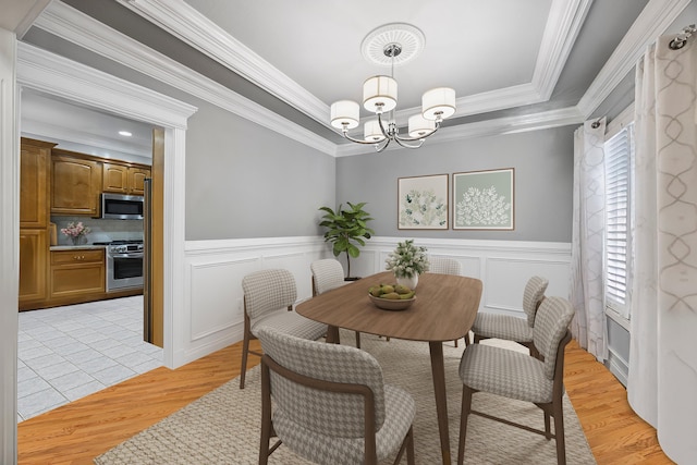 2507 Saint Lucie Ct, Chattanooga, TN 37421 - dining area with a chandelier, light wood-style floors, a raised ceiling, crown molding, and a wainscoted wall